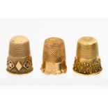 A Victorian gold thimble with cast scroll base, together with another Victorian gold thimble,