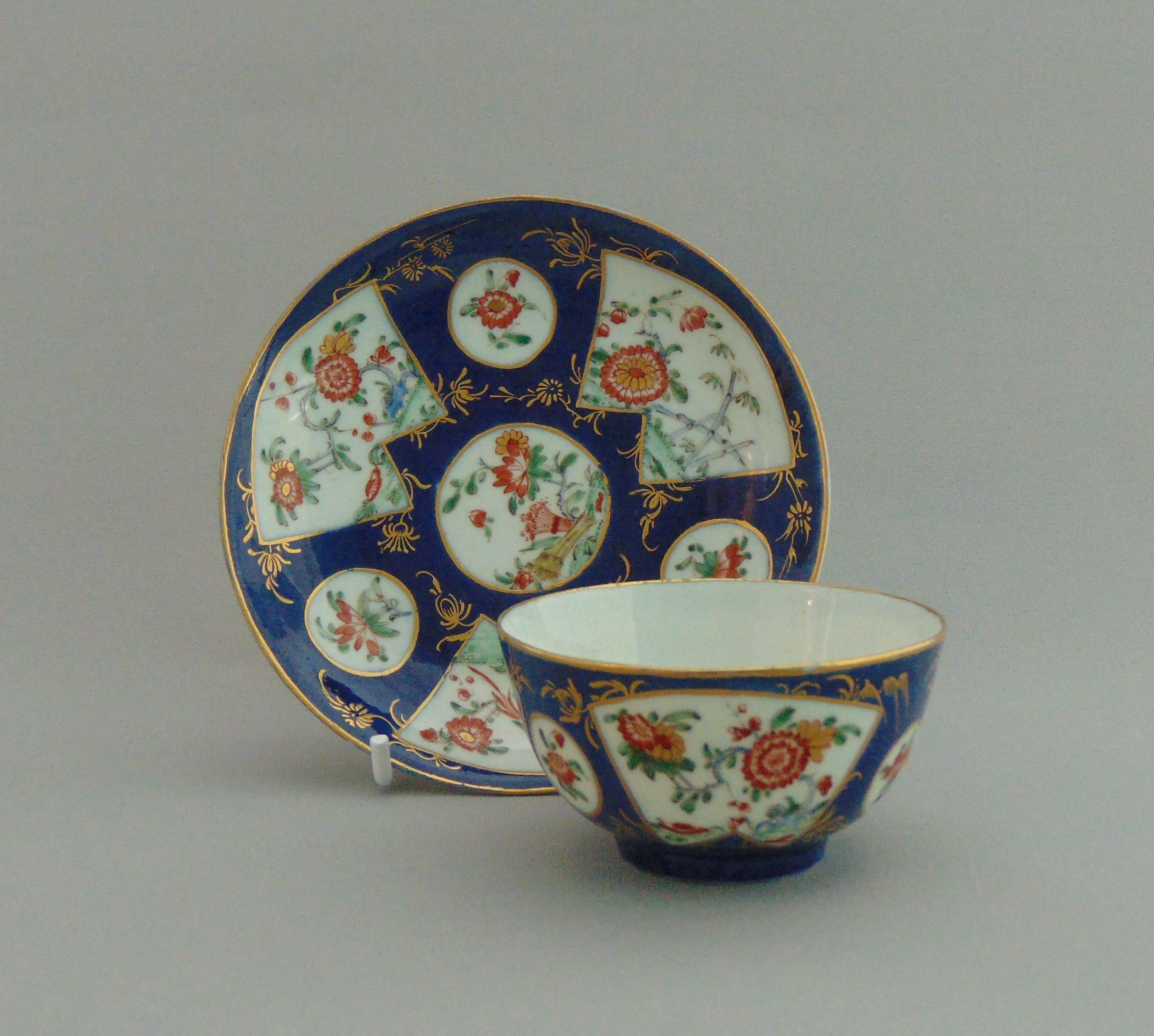 A Worcester tea bowl and saucer, blue powder ground,