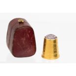 A cased Victorian 15ct gold and amethyst inset thimble with Greek key style chased ornament,