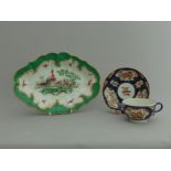 A Worcester green ground dish with painted birds in the centre and a Worcester blue scale tea cup