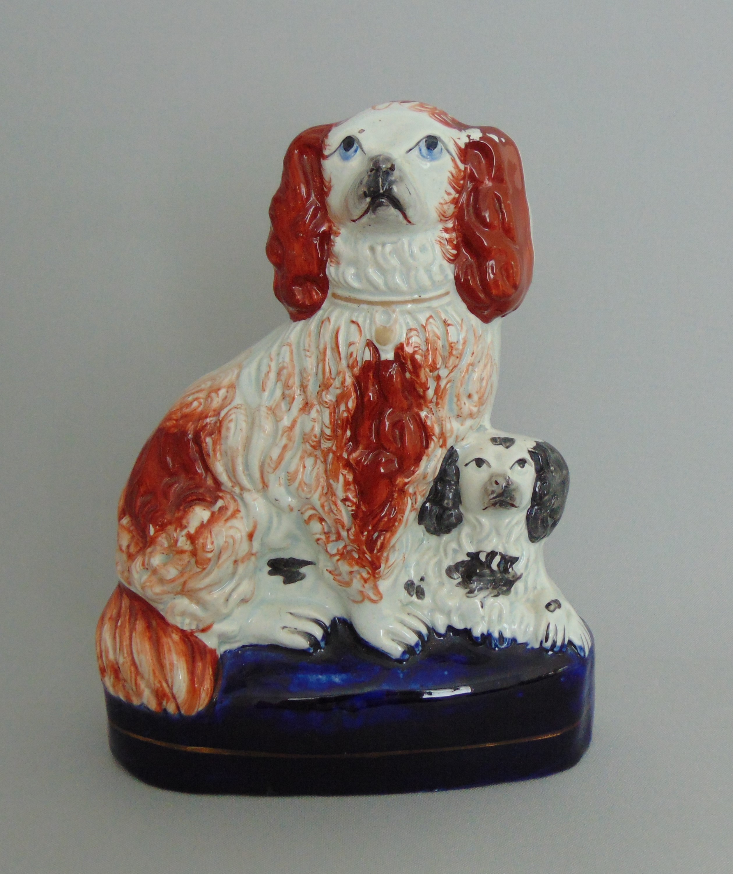 A Staffordshire group of two spaniels sitting on a cobalt blue glazed base, circa 1850,