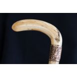 An antique marine ivory walking cane, the tooth crook handle engraved St Helena and dated 1901,