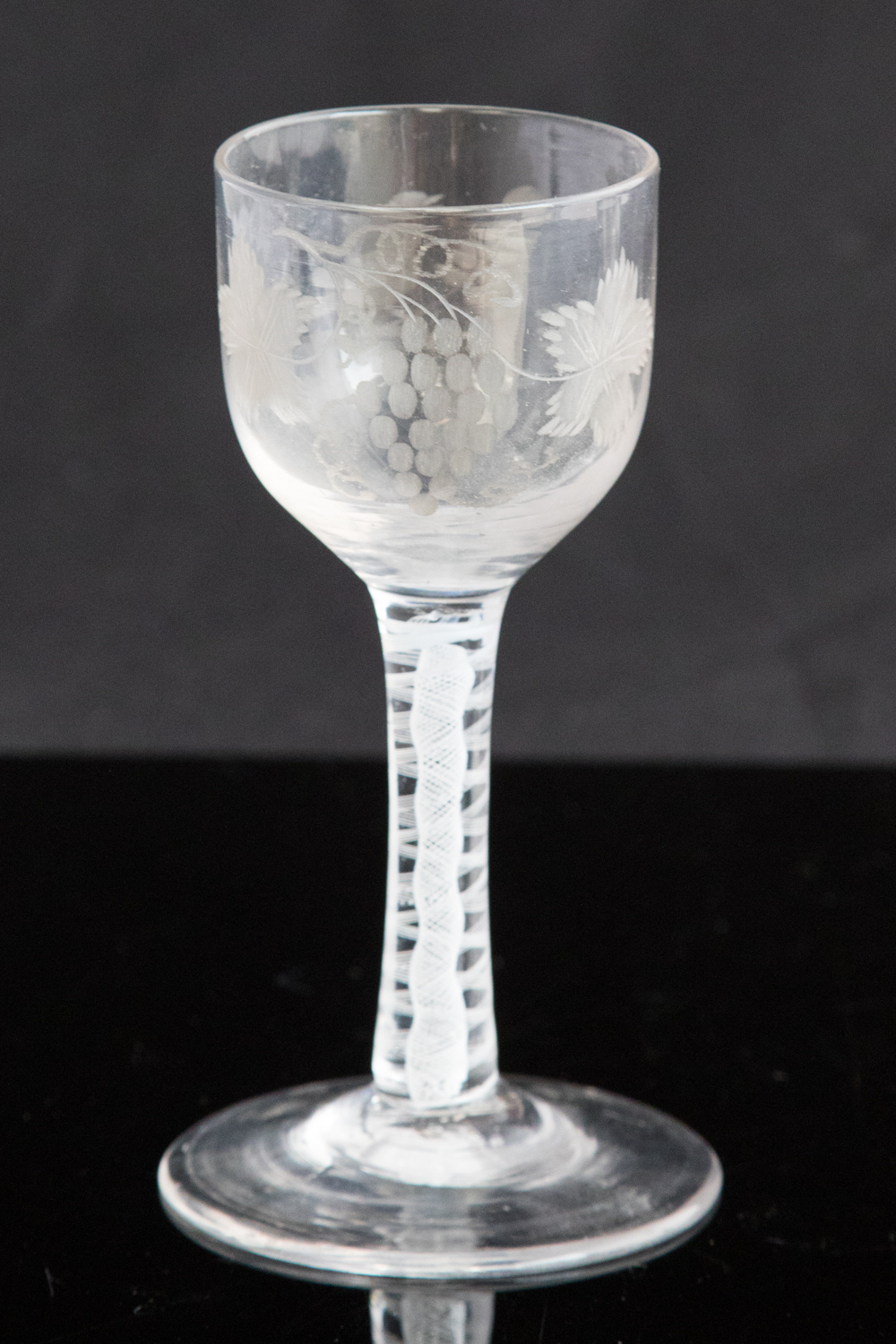 An 18th century wine glass, circa 1760, the ogee bowl engraved with wine and bird,