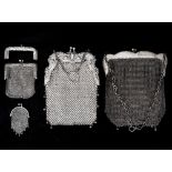 Four twentieth century white metal lady's chain mail purses, each with decorative mounts,