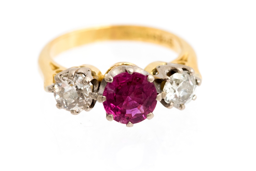 A ruby and diamond three stone yellow gold ring, the centre ruby approx 1ct,