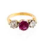 A ruby and diamond three stone yellow gold ring, the centre ruby approx 1ct,