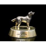 A George V silver and gilt novelty menu holder, with cast figure of a standing hound or dog,