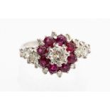 A diamond and ruby cluster ring, the central round brilliant cut diamond approximately 0.