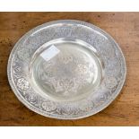 An Indian white metal dish with engraved decoration to rim and centre 17 cm in diameter approx,