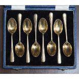 A boxed set of silver gilt coffee spoons, waved edge border pattern, hallmarked Sheffield 1961,