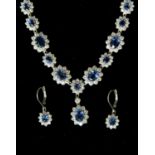 A sapphire and diamond multi-cluster white gold necklace with matching earrings,