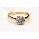 A diamond cluster ring, 18 ct gold band, seven stones in pave setting,