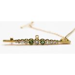 A diamond and peridot bar brooch in 18 ct gold