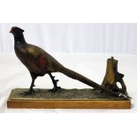 A painted spelter desk lighter, modelled as a cock pheasant, mounted on a wooden base, length 31.