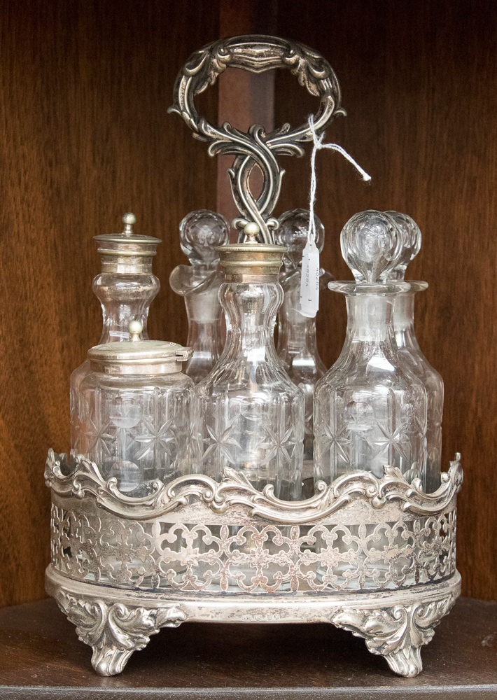 An early Victorian silver plated cruet set, the central section with a cast handle,