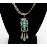 A Mexican jade, malachite and silver pendant in the form of an Aztec mask,