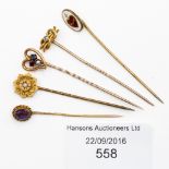 Five gold stick pins comprising pin set with amethyst, seed pearl,