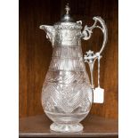 An electroplate mounted cut glass claret jug of baluster form with scroll handle, mask spout,