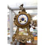 A 19th Century Rococo style gilt metal eight day mantle clock, the white dial with Arabic numerals,