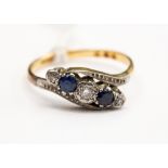 A diamond and sapphire four stone crossover ring, three illusion set diamonds and two sapphires,