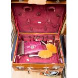 A leather travel case, containing some original pieces, including two silver hairbrushes,