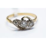 A three stone diamond ring in crossover setting, stamped 18ct plat, illusion set, ring size Q 1/2,