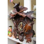 A carved wooden Cuckoo clock with three weights