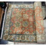 A faded red ground Persian carpet, stylised floral decoration,