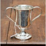 A twin handled Challenge Cup with filled base, hallmarks rubbed away, gross weight 13.