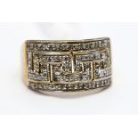 A 9ct gold ring set with diamond chips in Greek key pattern, approx 11 mm wide, ring size Q 1/2,