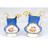 A pair of Victorian floral painted and blue ground jugs and monogrammed initial to the front of