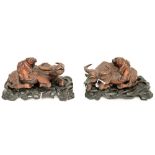 A pair of Oriental carved wood figures of a man sitting on the back of a recumbent ox,