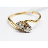 A diamond two stone 18ct gold cross over ring,