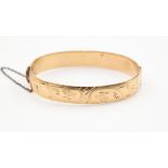 A yellow metal bangle approx 11 m wide, gross weight approx 28.
