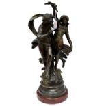 An early 20th Century spelter figure group of a scantily clad couple holding flowers,