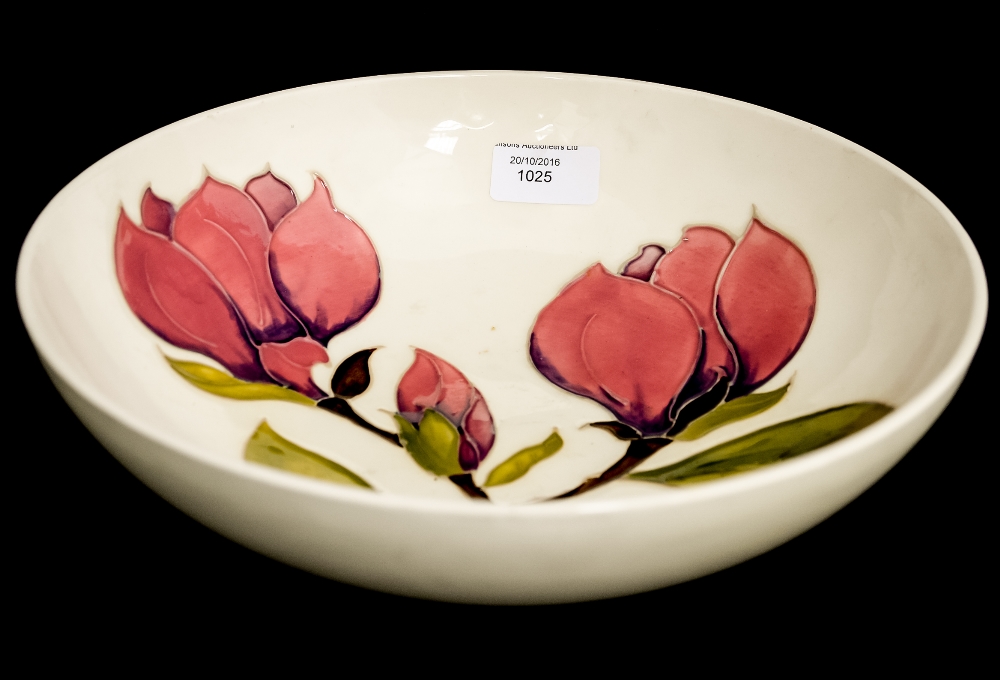 A Moorcroft pottery fruit bowl, cream ground with magnolia design, diameter 26.