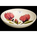 A Moorcroft pottery fruit bowl, cream ground with magnolia design, diameter 26.
