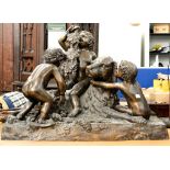 A large bronze figure group of three frolicking putti,