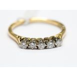 An 18ct gold five stone diamond and 18ct yellow gold ring, round brilliant cut diamonds,