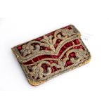 A red velvet, leather lined purse, with silver thread embroidery back and front,