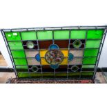 An Arts and Crafts stained glass panel, central painted pear cartouche, measures 68cm x 101.