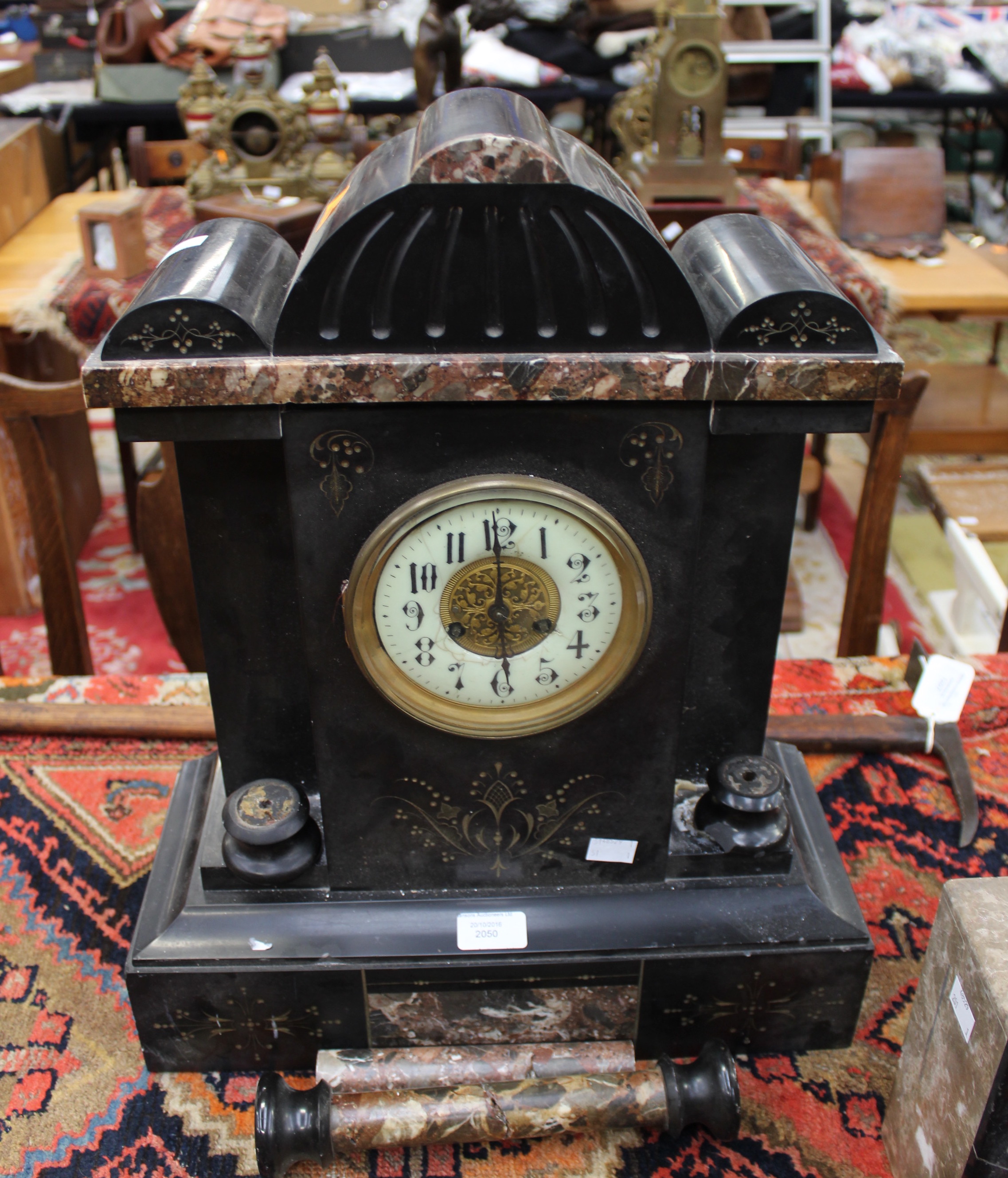 A 19th Century black slate mantle clock, with a circular white enamelled dial, Arabic numerals,