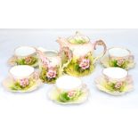A Continental hand painted teaset comprising five cups and saucers,