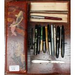 A lacquer box of assorted pens, to include a boxed Parker SI, phendic propelling pencil,