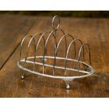 A George III wirework silver seven bar toast rack on an oval shaped base,