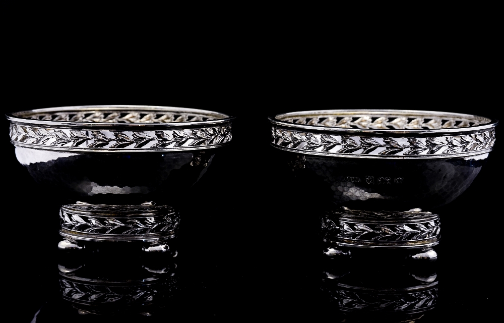 A pair of Arts and Crafts silver bowls, planished form with reticulated cast leaf rim and foot,