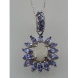 A 9 carat white gold, tanzanite, and opal cluster drop pendant, suspended on a 9 carat white gold