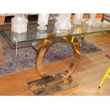 A contemporary glass and chrome console table, the rectangular glass top above a interlocking 'C'