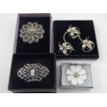 Four various silver brooches, to include a cameo brooch and three floral designs. (4)