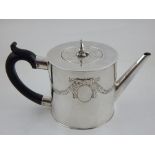 A George III circular silver teapot with detachable cover and ebonised handle the body embossed